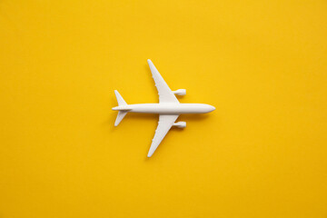 White passenger airplane on a summer yellow background. Travel and vacation background