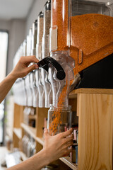 A man fills a jar with red lentils. Selling bulk goods by weight in an eco store. Trade concept...