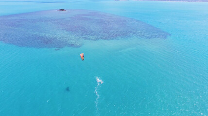 Aerial view of kitesurfing extreme sport with the wind freestyle. Beautiful top view of nice beach.