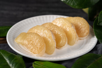 Fresh pomelo fruit on black slate background.