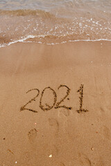inscription on the sand 2021. symbol 2021 on the coast, overlooking the sea. Summer holidays in the new season.