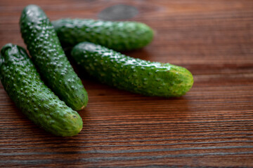 Fresh cucumbers on a dark wooden background.