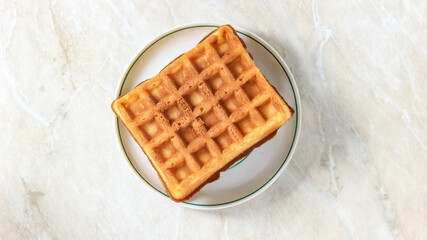 Soft rectangular Viennese waffles on a saucer. Delicious dessert.
