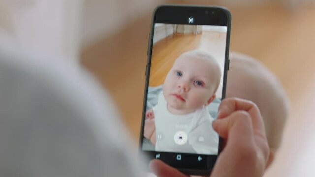 mother taking photo of baby using smartphone enjoying photographing cute toddler sharing motherhood lifestyle on social media