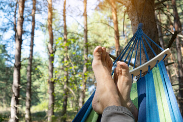 Relaxing on a hammock tied to trees. Summer relaxation background.