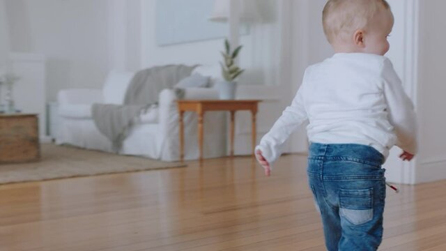 cute baby boy learning to walk toddler exploring home curious infant walking through house enjoying childhood