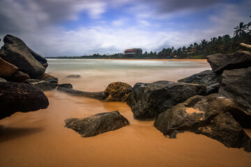 The coast of Sri Lanka, with stones in the foreground. Sunset on the sand beach. sea