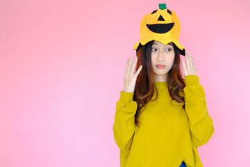portrait asian cute girl wearing casual clothes with halloween hat posing, holiday halloween concept on pink background