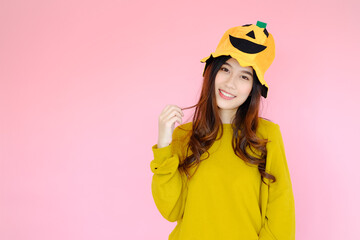 portrait asian cute girl wearing casual clothes with halloween hat posing, holiday halloween concept on pink background