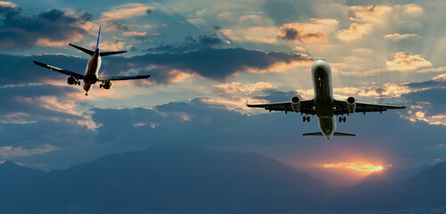 Colorful sunrise with clouds landing and taken off airplanes, concept of travels and vacations