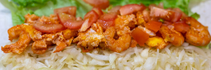cooking homemade fast food roll close up. cabbage, fried shrimp and tomatoes with cheese on pita bread. a quick and delicious hearty snack for school or work. banner