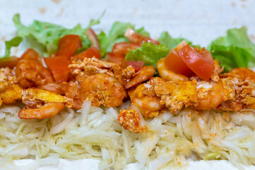 cooking homemade fast food roll close up. cabbage, fried shrimp and tomatoes with cheese on pita bread. a quick and delicious hearty snack for school or work