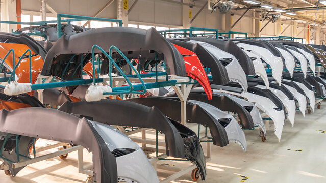 Auto bumpers parts are installed on the racks after painting in the car factory. Industry concept.