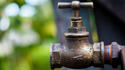 old brass water tap isolated on a light background. tap valve. old copper retro faucet on a rusty pipe. plumbing, repair, dismantling. Vintage close-up. outdoor water tap