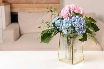 Beautiful hortensia flowers in vase on white table indoors. Space for text