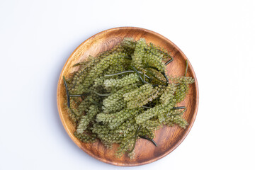 Seaweed, bunch of grapes in a wooden cup on white background.