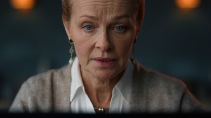 Old woman talking at online meeting on laptop computer.