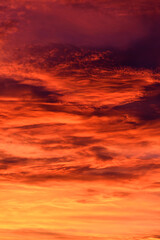 Beautiful, dramatic fiery orange sky and clouds after the sunset, vertical