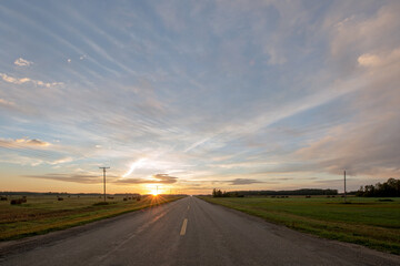 Sunrise on a country highway in rural Saskatchewan in the Canadian prairies.