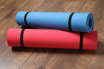 Bright rolled camping mats on wooden background