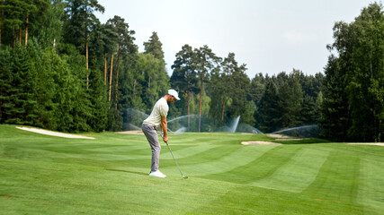 Fototapeta premium Young golfer in uniform playing golf