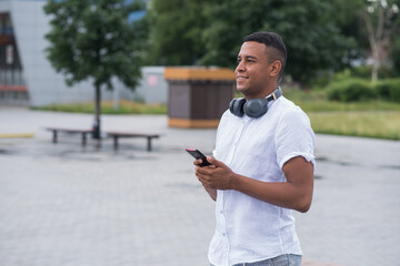 Fototapeta premium Portrait of a young and happy African American man who using a smartphone. Freelance concept