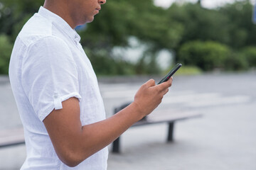 Portrait of a young and happy African American man, using a smartphone. Freelancer, chatting, texting