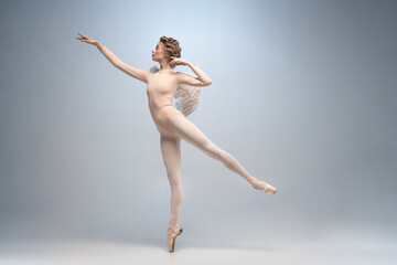 Young and graceful ballet dancer, ballerina dancing isolated on white gray studio background. Art,...