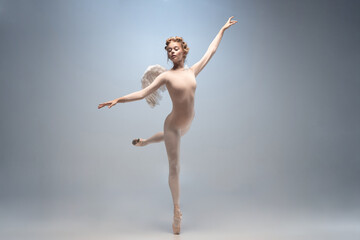 Young and graceful ballet dancer, ballerina dancing isolated on white gray studio background. Art,...