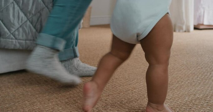 baby taking first steps toddler learning to walk with mother gently helping infant teaching child at home motherhood trust