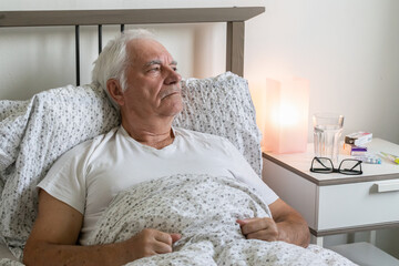 aging senior man male bed sick ill alone retired resting virus unhappy sad
