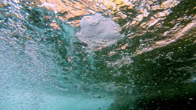 Underwater view of stick caught in a small eddy at is swirls around.