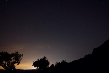 Picturesque view of starry sky at night over hill