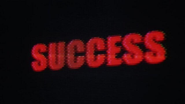 Success red text flashing on screen close-up - distorted image from vintage CRT display - conceptual footage