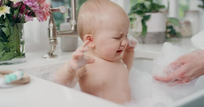 mother bathing crying baby with mom washing little infant having tantrum 