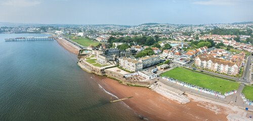Aerial drone shot over sea looking at a scenic panorama view of Paington and the beach