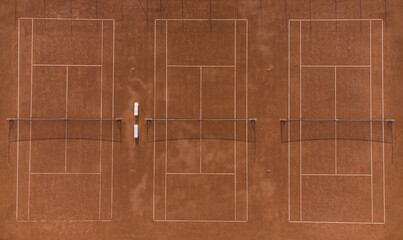 Aerial top down view of red gravel tennis courts