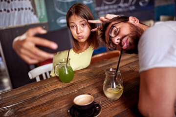 Urban couple taking a selfie in a cafe; Casual lifestyle concept
