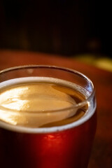 Pint glass with beer, amber lighting in a public house