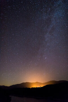 Milky Way starry night sky over hills and trees Sardinia Italy
