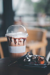 A glass of iced coffee and men wallet, mobile phone and key car