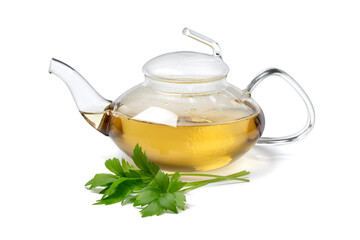 Glass teapot with lovage tea and a fresh twig of lovage in front isolated on white background 