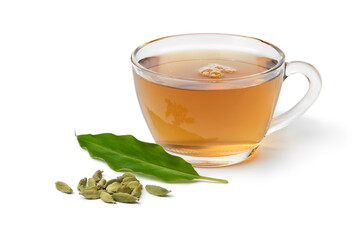 Glass cup with Cardamom tea and a heap with cardamom seeds and leaf in front isolated on white...