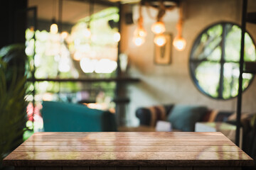 Empty wooden table top with lights bokeh on blur restaurant background.