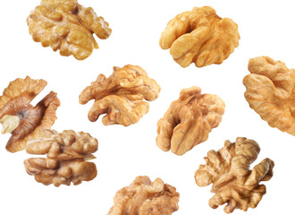 Halves of walnuts falling on white background