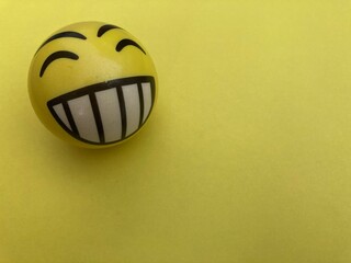 Pelota happy face amarillo sobre fondo amarillo