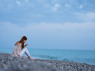 Fototapeta na wymiar woman sitting on the shore beach ocean landscape fresh air