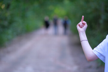 Middle finger up. Social problems, bullying, improper upbringing. An offensive gesture.