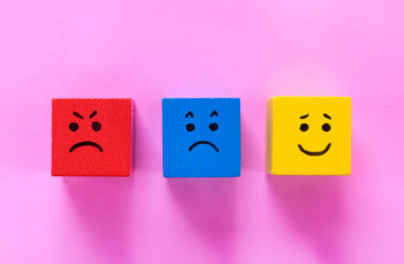 Red, blue and yellow cubes with cute faces depicting human emotions: anger, sadness and happiness....