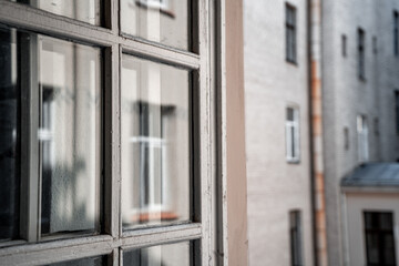Fototapeta na wymiar Wooden vintage white window frame and house outside the window on blur (997)